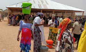 Woman leaving with bucket on head crop (Zuru)