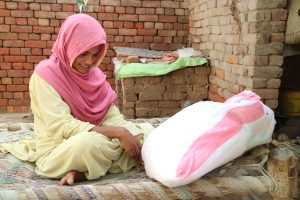 Young woman smiling at bag of aid